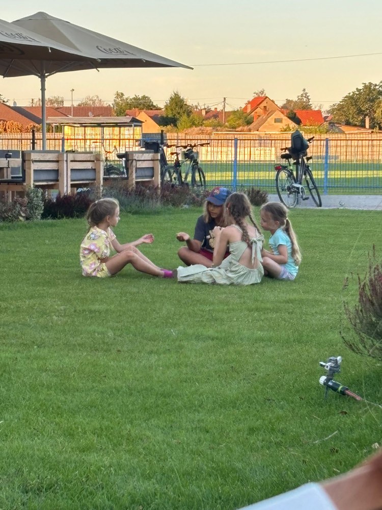 Deti sa hrajú na trávniku v areáli penziónu